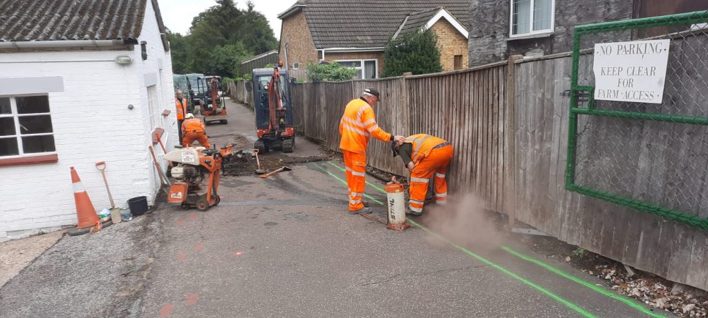 A group of men working on a fence in front of a house Holme Farm Community Gardens & Workshops